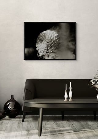 Lunar Bloom III by Guido Lucker framed above a dark sofa beside a candlestick and a vase