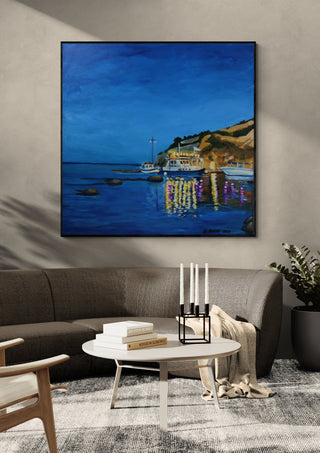 Evening Boats by Nella Hajdu in a black frame above a grey sofa with a round coffee table and candlesticks