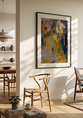 Torso in Yellow by René J in a black frame in a bright dining room with wooden chairs