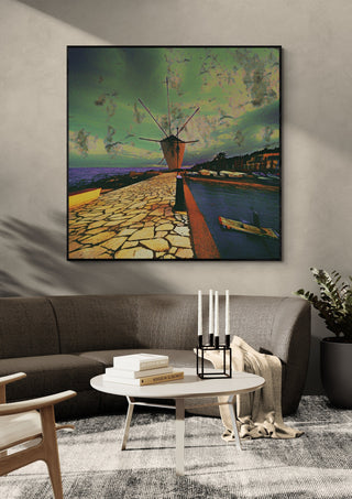 Garitsa Windmill by Pelecan Schneider in a black frame above a grey sofa with a round coffee table and candlesticks