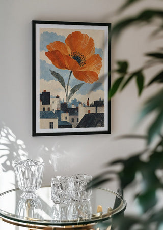 Blooming Above the Roofs by Matthews Gallerie in a black frame above a glass table with crystal glassware