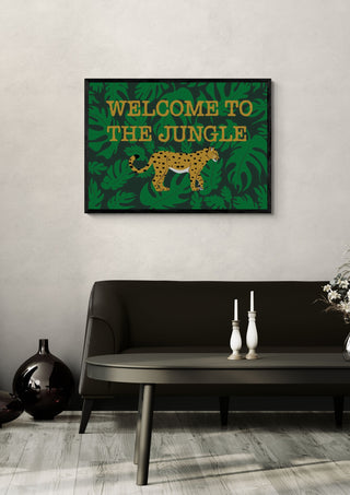 Welcome to the jungle by Lisen Vennesland in a black frame above a dark sofa with candlesticks and a vase