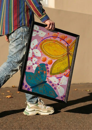 Gentle things by LGDyrby carried in a black frame along a sunny street