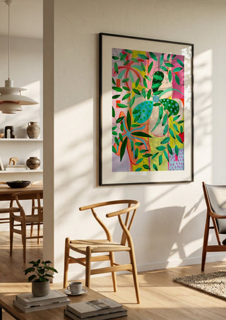 Bloom by LGDyrby in a black frame in a bright dining room with wooden chairs