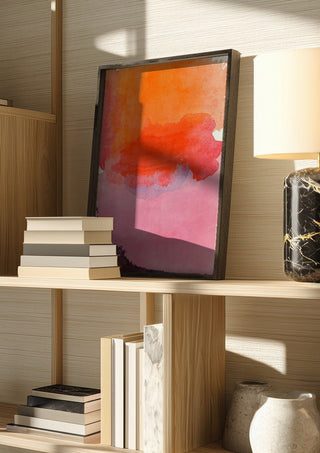 From sunset to sunrise by Ohkimiko in a dark frame on a wooden shelf beside books and a lamp