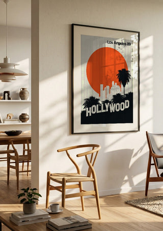 Los Angeles 89 by Bo Lundberg in a black frame in a bright dining room with wooden chairs
