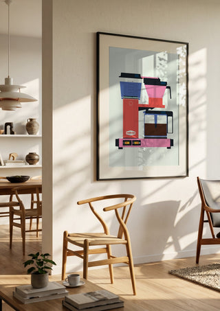 Pastel coffee by Bo Lundberg in a black frame in a bright dining room with wooden chairs