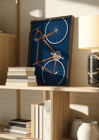Swedish Racing Bike by Bo Lundberg in a dark frame on a wooden shelf beside books and a lamp
