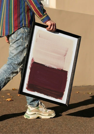 colorfields pale pink warm red by Iris Lehnhardt carried in a black frame along a sunny street