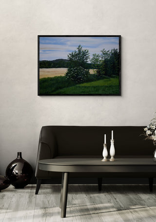 Elderflower by Juergen Duerrmann in a black frame above a dark sofa with candlesticks on a round table