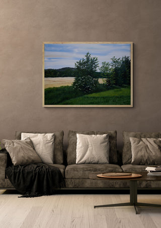 Elderflower by Juergen Duerrmann in a light oak frame above a grey sofa on a warm brown wall