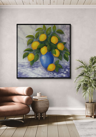Lemons for You and Me by Tako in a black frame above a leather armchair beside a palm