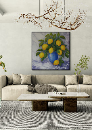 Lemons for You and Me by Tako in a black frame above a cream sofa under a branch chandelier