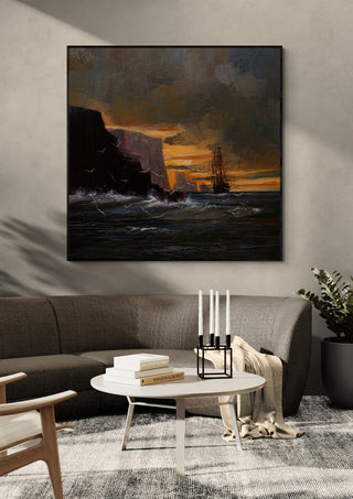 Ship by the Cliffs by Justyna Kopania in a black frame above a dark sofa with candlesticks on a round table