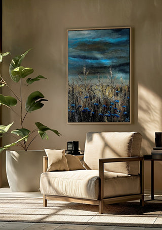 Blue fields by Lüba framed above a beige armchair beside a potted plant