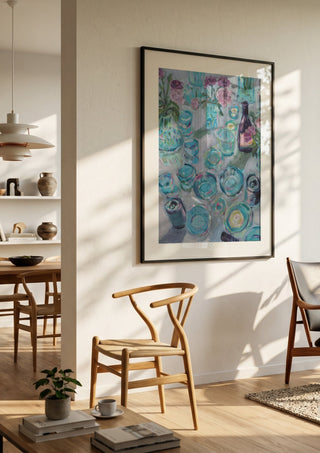 Garden Summer Party by DNF in a black frame in a bright dining room with wooden chairs