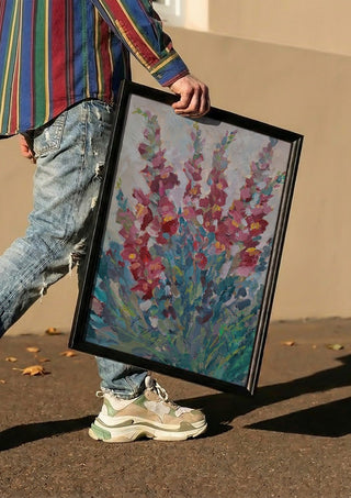 Red Snapdragon Flowers by DNF carried in a black frame along a sunny street