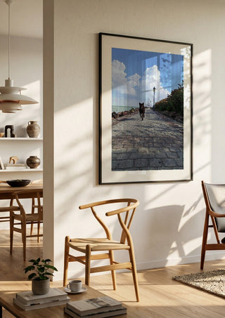 Departure and Return by Bora Kőhalmi in a black frame in a bright dining room with wooden chairs
