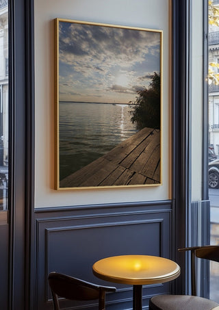 Sunset at the Lakeside Dock by Bora Kőhalmi in an oak frame on a panelled café wall