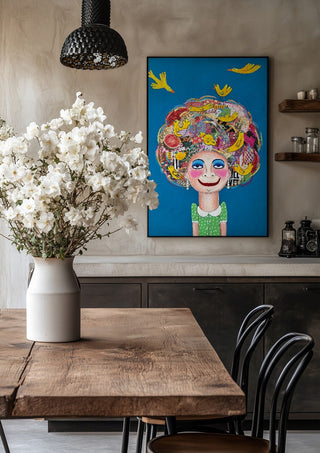 Pájaros en la cabeza by María Burgaz in a black frame above a rustic table with white flowers