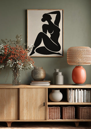 Abstract Black Nude Woman by TimlessArtworks above a wooden sideboard on a sage green wall