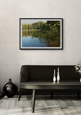 Sommar skuggan by Ljilja Marinic in a black frame on a pale wall above a dark sofa with candlesticks