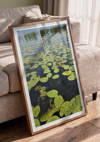 Sommarens sista andetag by Ljilja Marinic in a walnut frame leaning against a grey sofa