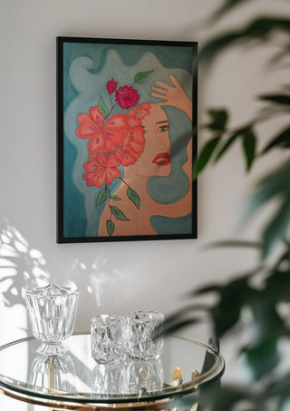 Flowers in head by Carmen Coduri in a black frame above a glass table with crystal glassware