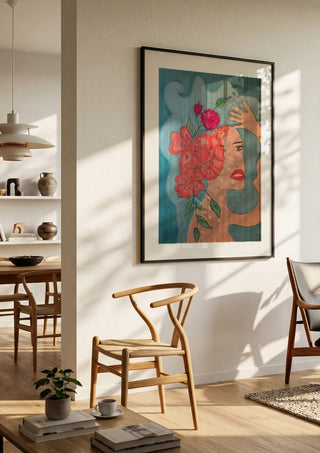 Flowers in head by Carmen Coduri in a black frame in a bright dining room with wooden chairs