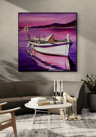 Boat in Pink by Sunny in a black frame above a grey sofa with a round table and candlesticks