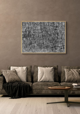 Unusual Landscape by Priit Ruttas in a pale wooden frame above a grey sofa with cushions