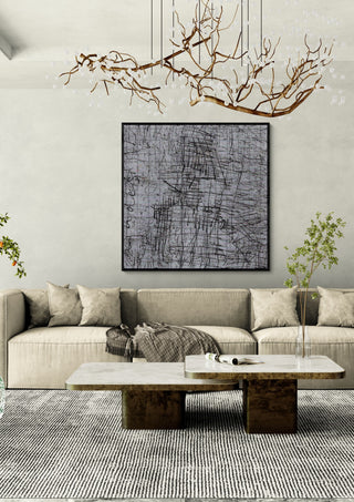 looks like a house by Priit Ruttas in a black frame above a beige sofa under a branch chandelier