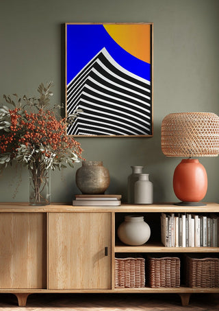 Pyramid by Aleksi Allan above a wooden sideboard on a sage green wall
