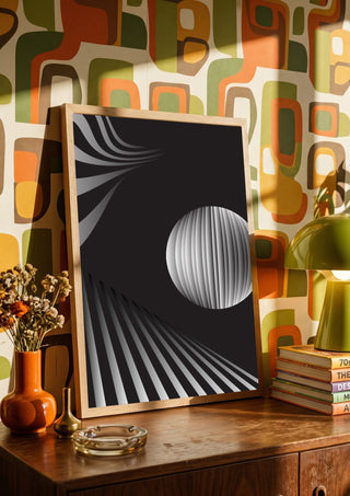 Monochrome II by Aleksi Allan in a wooden frame on a sideboard against a retro patterned wall