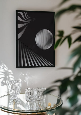 Monochrome II by Aleksi Allan in a black frame above a glass table with crystal glassware