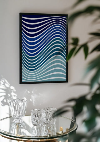 Aallot by Aleksi Allan in a black frame above a glass table with crystal glassware