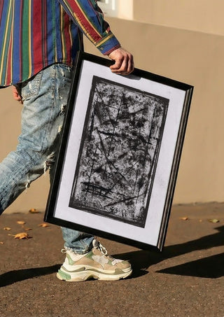 Black Field by David Pernecker carried in a black frame along a sunny street