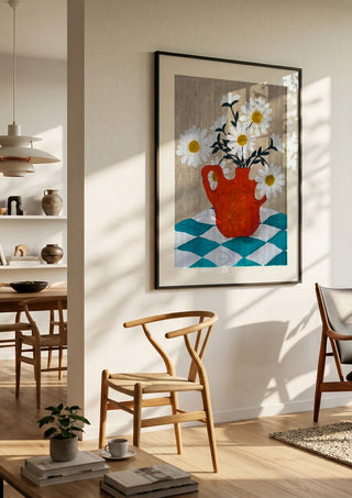 Vita blomster i röd vas by Rebecka Hansson in a black frame in a bright dining room with wooden chairs