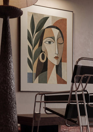 Cubist Woman Portrait with Plant by TimlessArtworks framed in a dim room beside a tubular steel chair