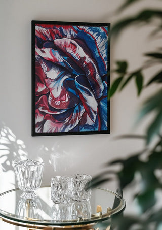 Rose by Okiana in a black frame above a glass table with crystal glassware