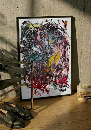 Tangle by Ronald Rumell in a black frame leaning against a concrete wall by a steel chair