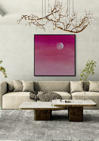 Pink Atmosphere by Marina Agre in a black frame above a beige sofa under a branch chandelier