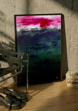 Emerald and Carmine by Marina Agre in a black frame leaning against a concrete wall by a steel chair