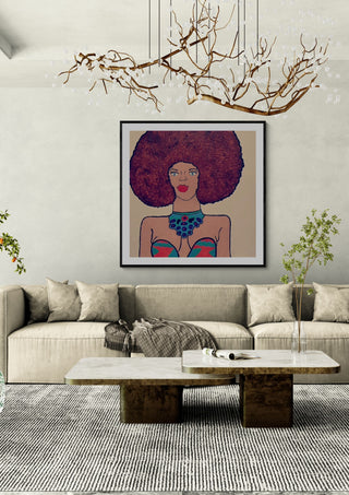Afrocentric Radiance by Bibi in a black frame above a beige sofa under a branch chandelier