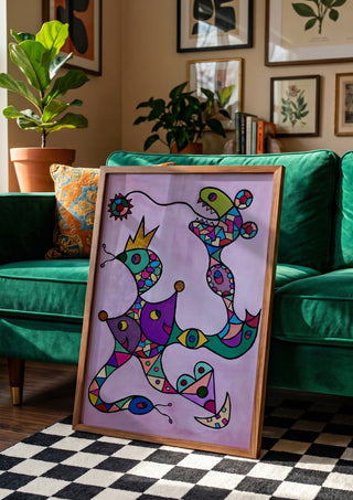 Crowned Creatures by Steffi Seiler in a wooden frame beside a green velvet sofa on a chequered floor