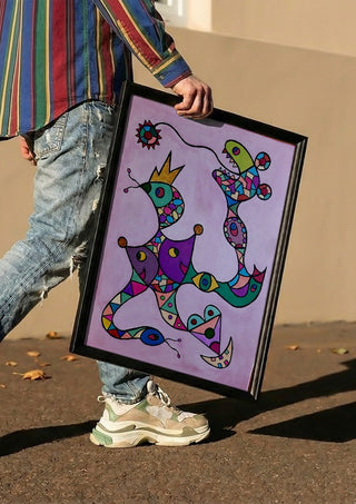 Crowned Creatures by Steffi Seiler carried in a black frame along a sunny street