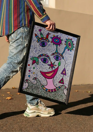 Eyes and Flowers by Steffi Seiler carried in a black frame along a sunny street