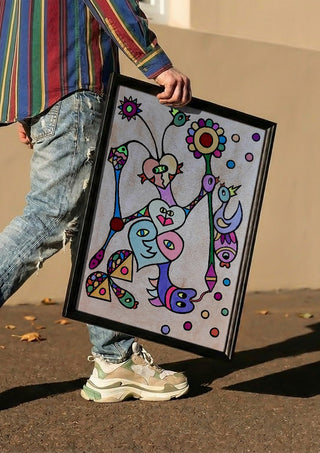 Hearts and Sunflower by Steffi Seiler carried in a black frame along a sunny street