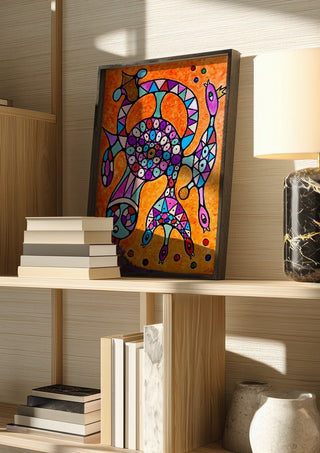 Circle of Eyes by Steffi Seiler in a dark frame on a wooden shelf beside books and a lamp