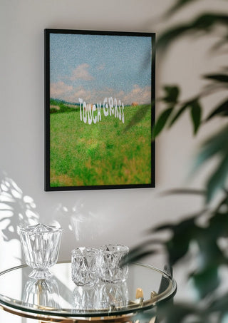 Touch Grass by Jakob Falkenberg in a black frame above a glass table with crystal glassware